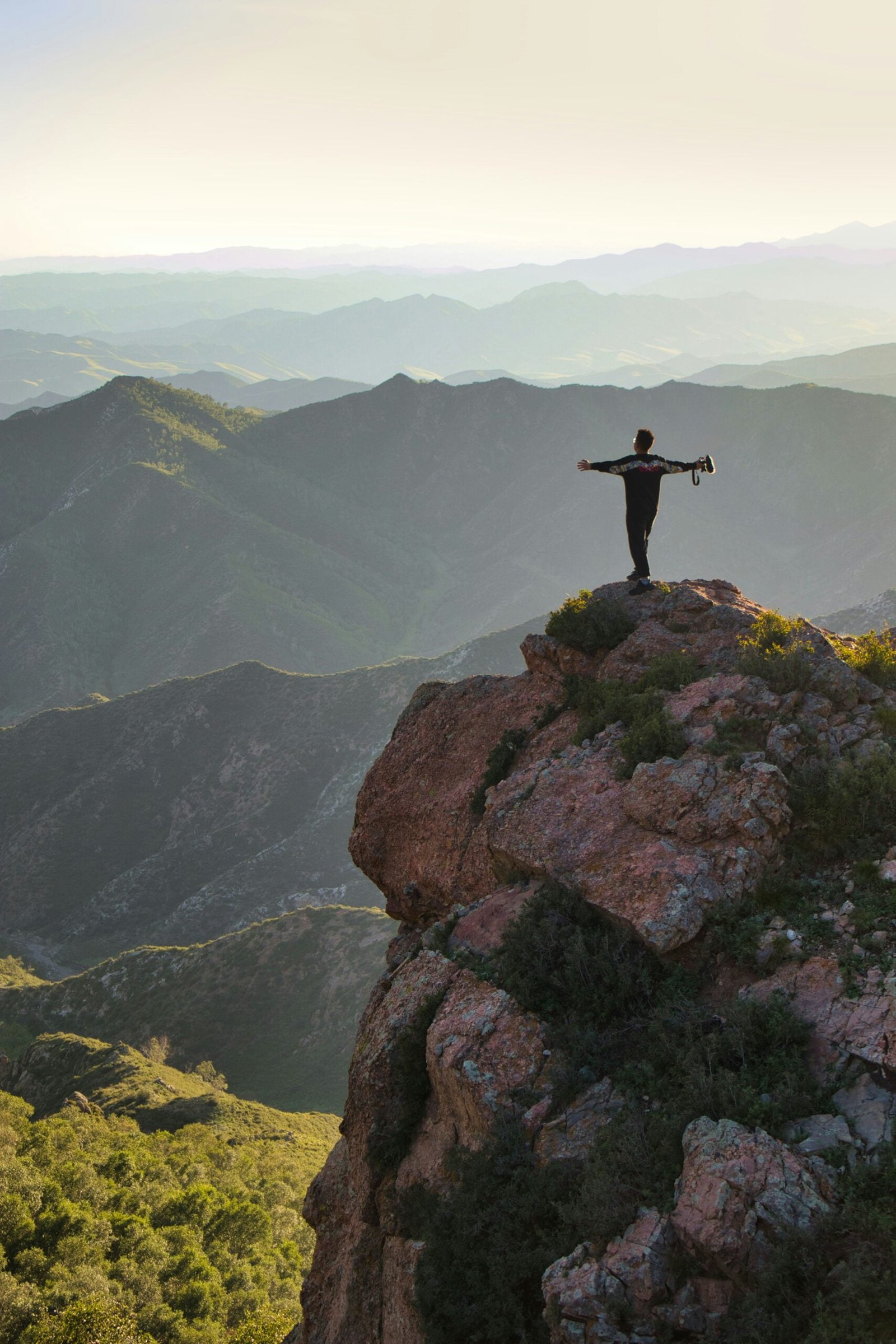 man standing on rock formation during daytime